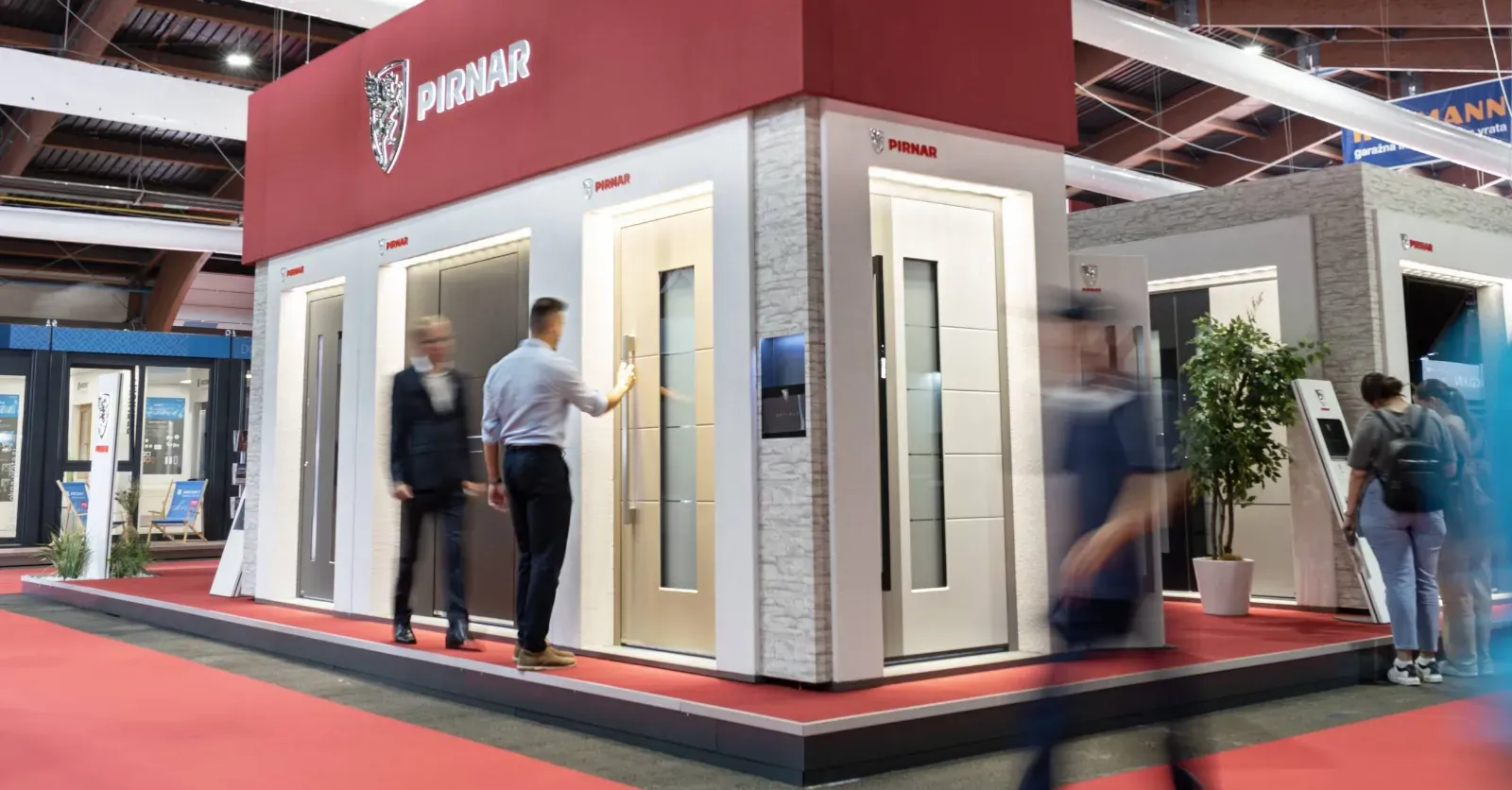 Na razstavi so prikazane različne vhodne vrata z različnimi oblikami in materiali.