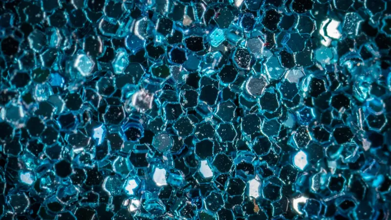 Na sliki so prikazani večbarvni šesterokotniki, ki tvorijo teksturo s svetlečimi in mat površinami.