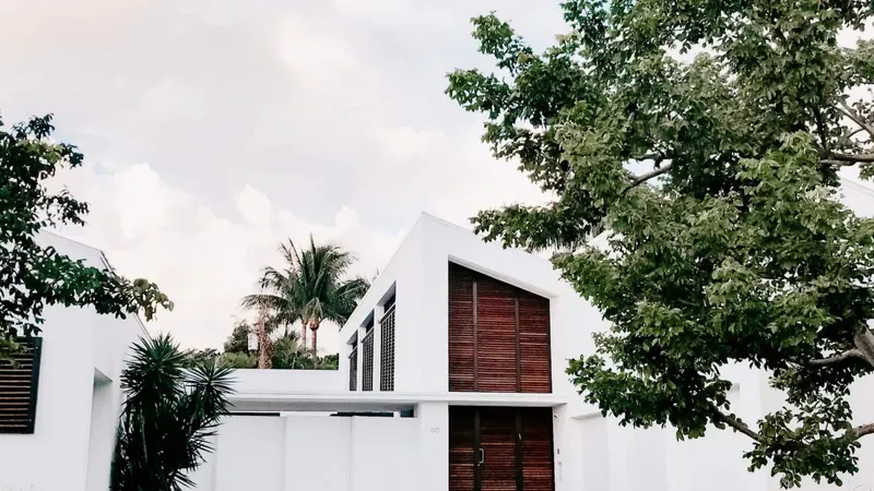 Lesena vrata z večimi lamelami so vgrajena v belo zgradbo.