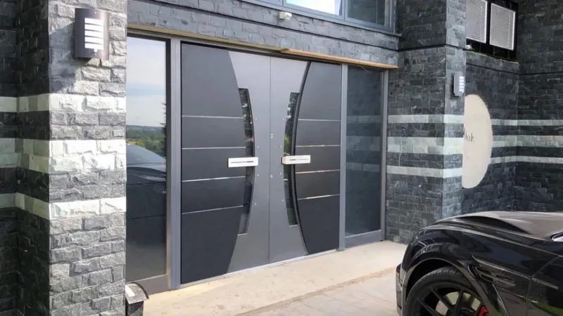 Dvojna vrata s steklenimi vložki in kovinskimi ročaji na moderni stavbi.