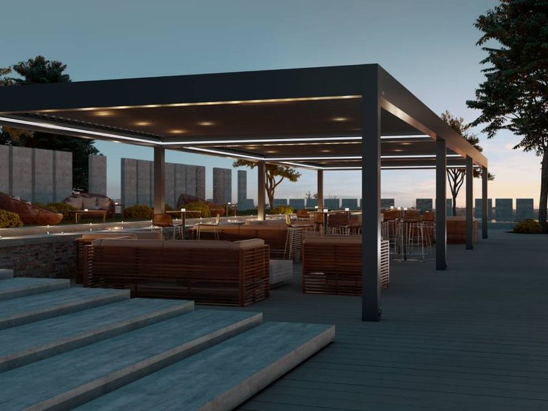 Pergola s streho in osvetlitvijo, obdana z lesenimi sedeži in barom.