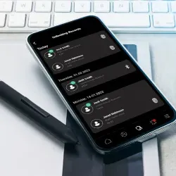 Na sliki je pametni telefon s prikazom sporočil na temnem ozadju.