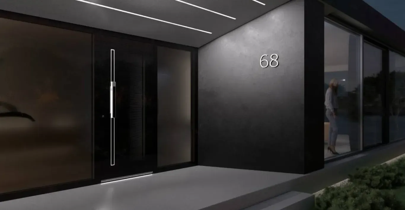 Vhodna vrata s stekleno površino in kovinskim ročajem ter številka hiše 68 na steni.