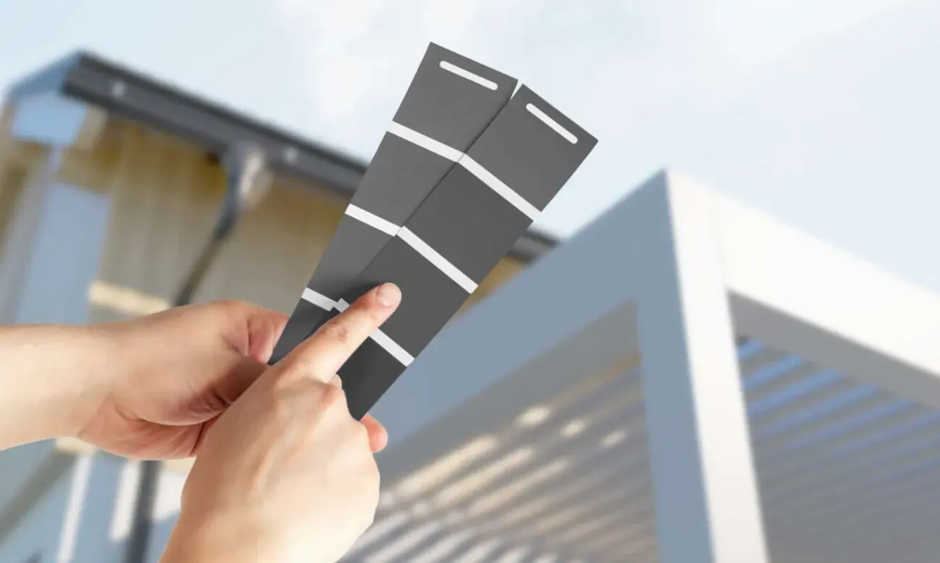 Oseba drži dva vzorca barvnih trakov za pergolo.